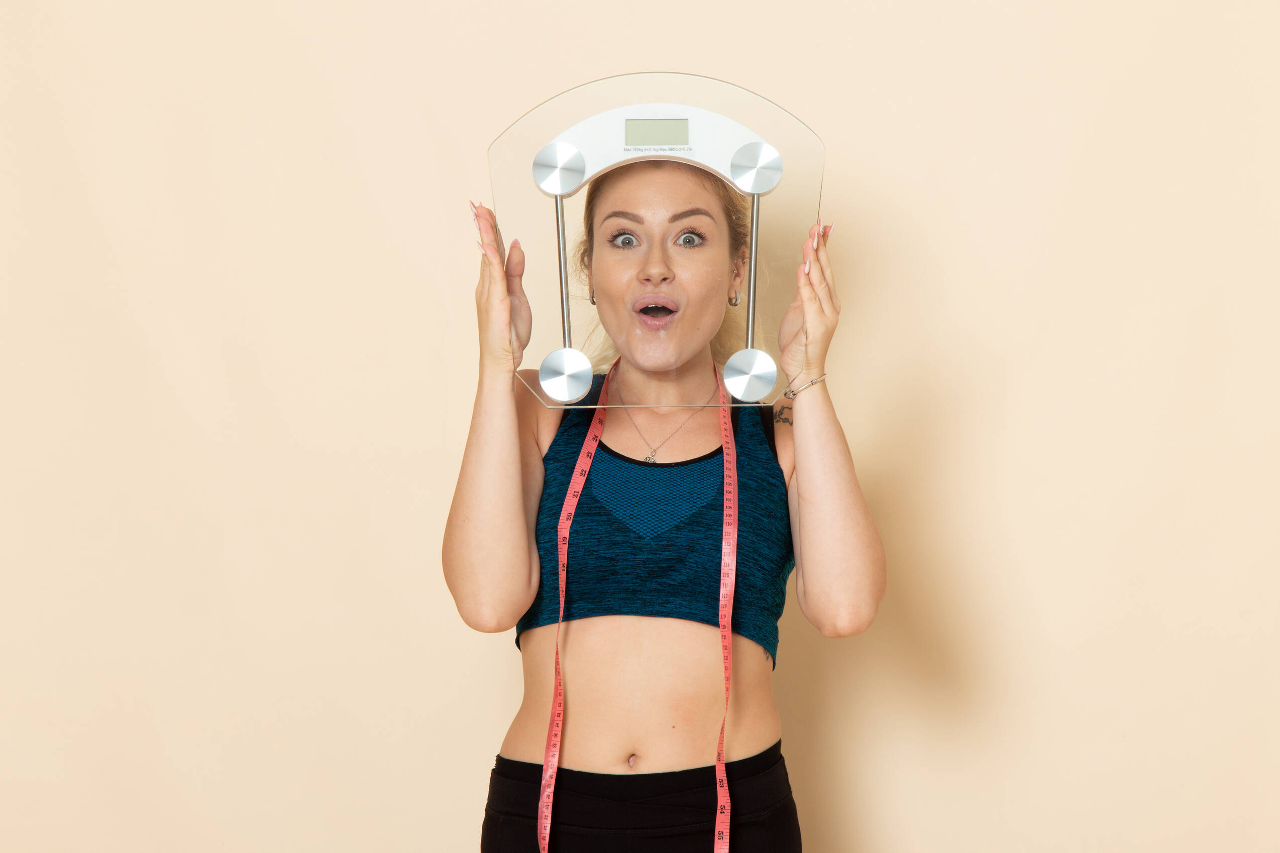 Front view young female sport outfit holding scales white wall fit body sport beauty health exercises
