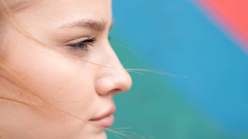 Young focused blonde woman outdoors training multicolored background