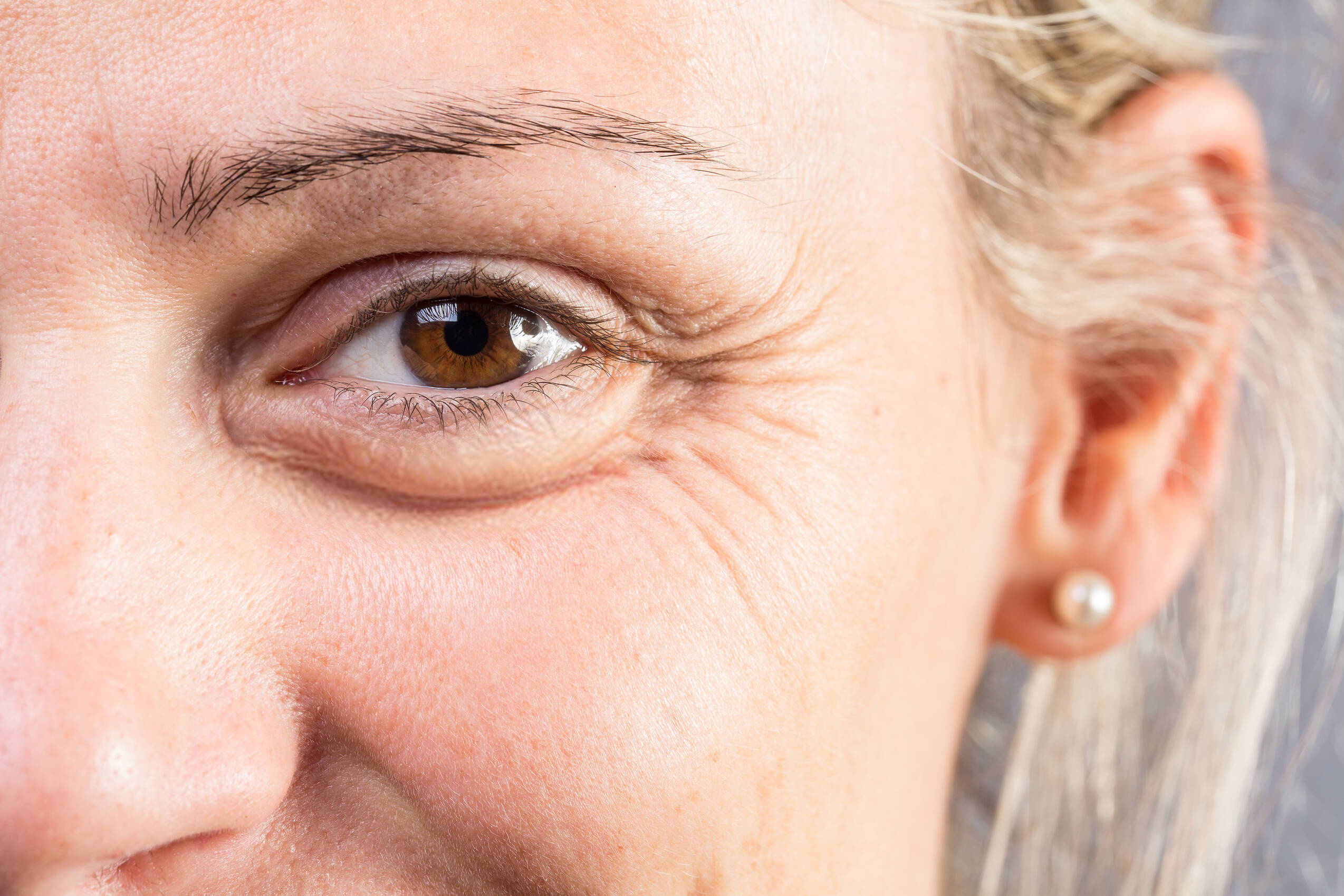 Macro eye smiling woman showing signs age such as crows feet wrinkles